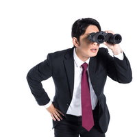 双眼鏡で何かを探すスーツ姿のエージェントの写真