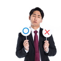 正解が分からず最後まで悩む○×クイズの男性の写真