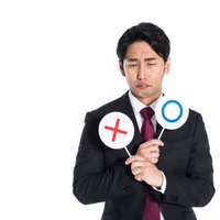 クイズの正解が分からず諦めモードの男性の困惑した表情の写真