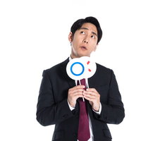 ○×クイズの正解を考えるスーツ姿の男性の判断の写真