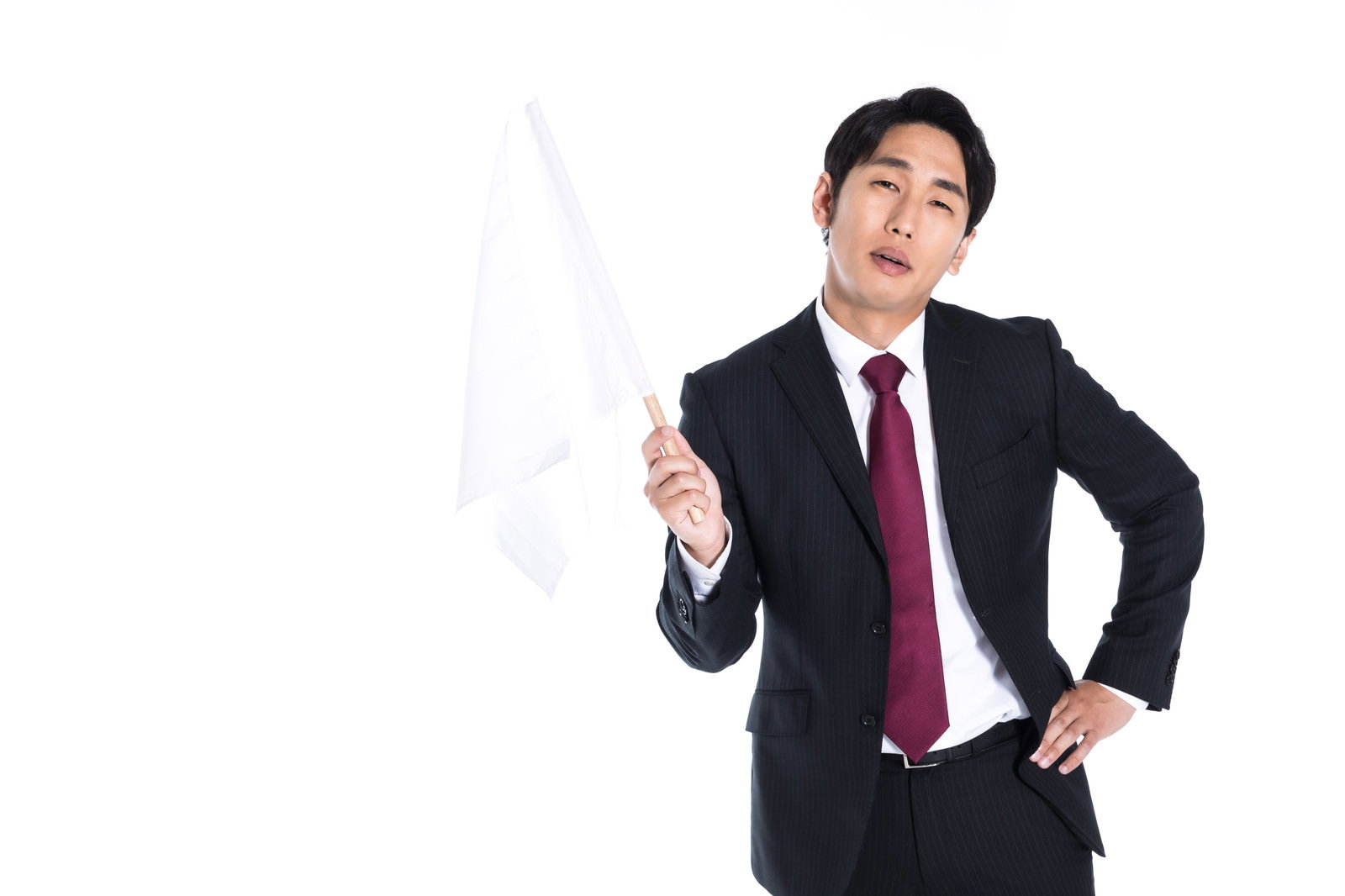 嫌々白旗を揚げるスーツ姿の会社員［モデル：大川竜弥］