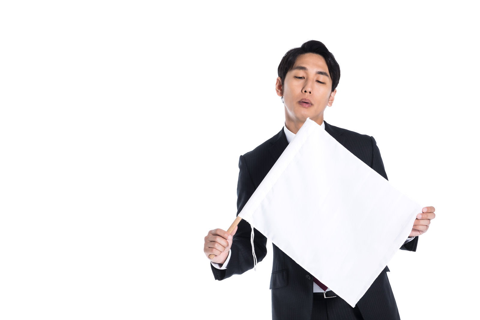 白旗を持ったスーツ姿の会社員男性［モデル：大川竜弥］