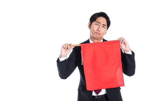 赤い旗を両手で掲げて危険を知らせる会社員