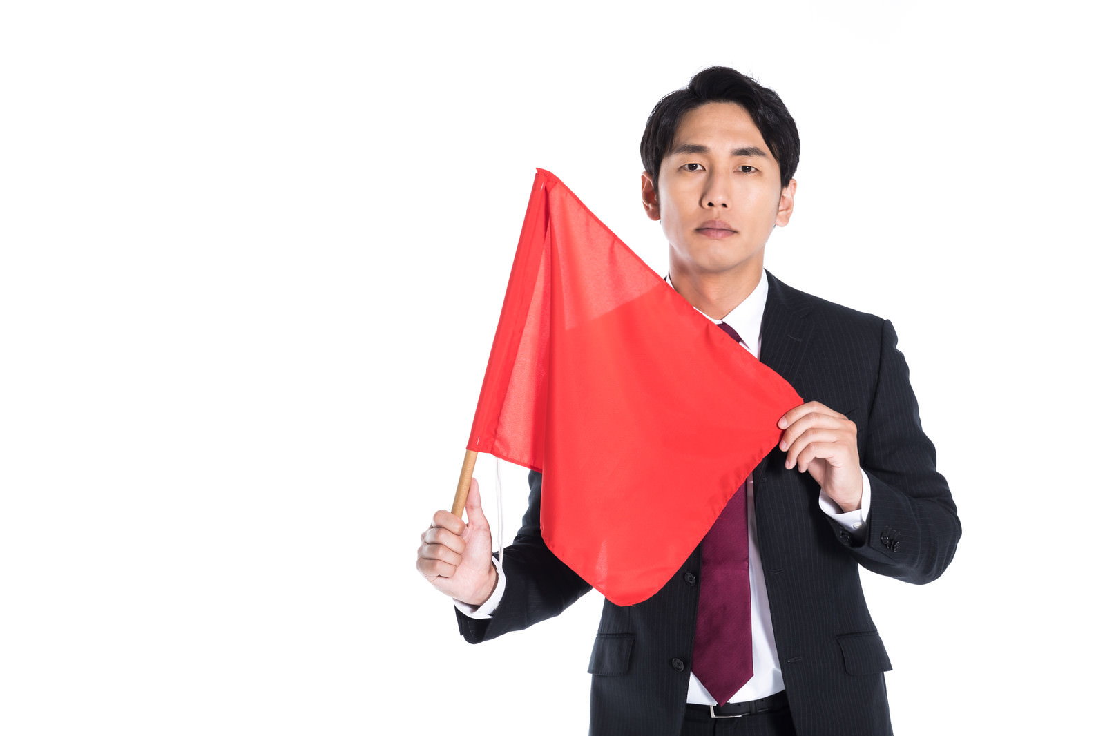 スーツを着た男性が赤い手旗を両手で持ち危険を知らせるポーズ［モデル：大川竜弥］