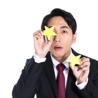 もう少しで二つ星でした。星シールで評価を表現するビジネスマンの写真