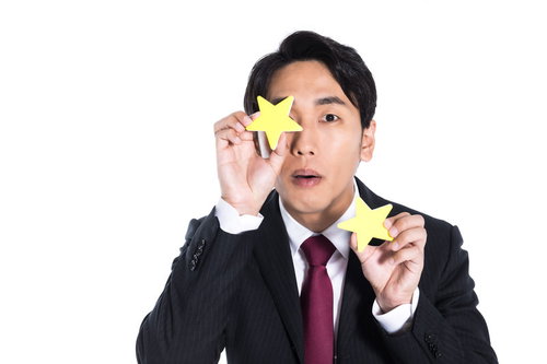 もう少しで二つ星でした。星シールで評価を表現するビジネスマン