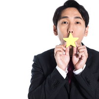 低評価の一つ星を掲げるスーツ姿の男性の写真