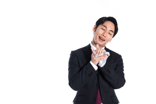 スーツ姿でハンカチを口元に当てる男性
