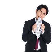 イライラして肩を落とし、ハンカチを噛む男性の写真