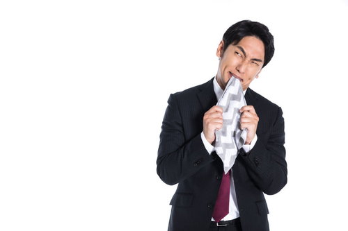 イライラして肩を落とし、ハンカチを噛む男性