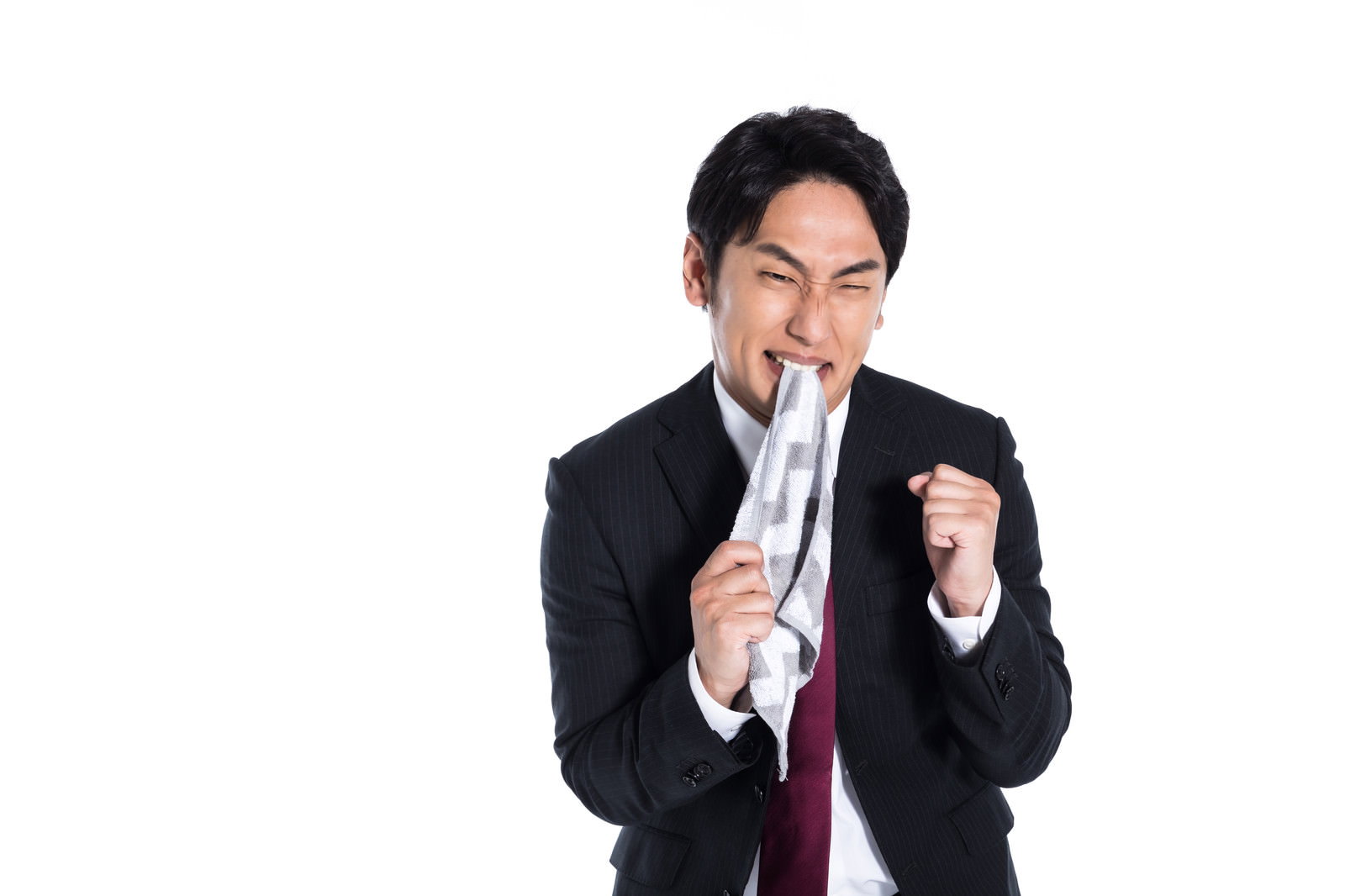 ハンカチを噛んで悔しそうな表情の黒いスーツを着た男性［モデル：大川竜弥］