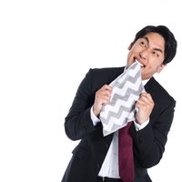 同期の出世に嫉妬し悔しさで悶々とするスーツの男性の写真