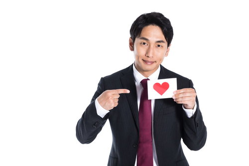 いいねマークを指さすスーツの男性のSNS評価ビジネス