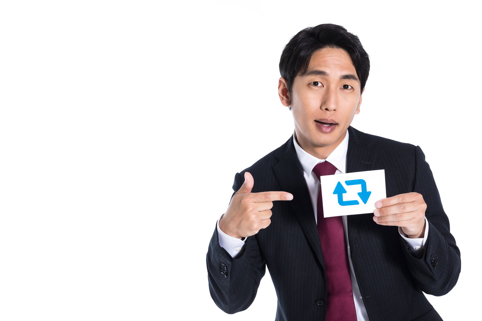 黒いスーツを着た営業マンが指を差すポーズで自信に満ちた表情を見せている［モデル：大川竜弥］