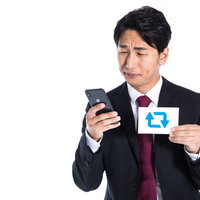 就職してからRT数が伸びなくて困っているスーツ姿の男性の写真