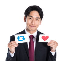 リツイートといいねマークを持つビジネスマンの写真
