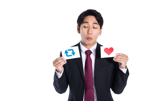 RTと「いいね」で迷うスーツ姿の会社員