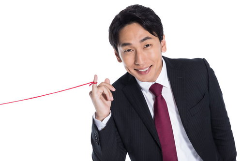 運命の赤い糸を見せびらかす黒いスーツの男性