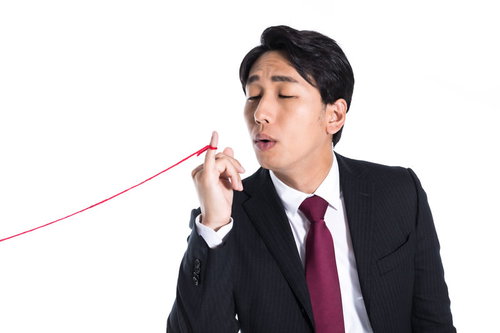 赤い糸を必死に手繰り寄せるサラリーマン