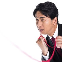 運命の赤い糸をたぐり寄せるスーツ姿の独身男性の写真