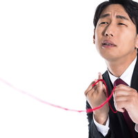 赤い糸を手繰り寄せるスーツ姿の独身男性の運命の出会いの写真