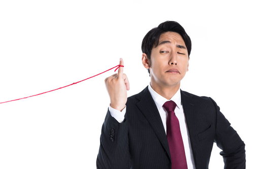 高所得者を狙う赤い糸に束縛される男性ビジネスマン