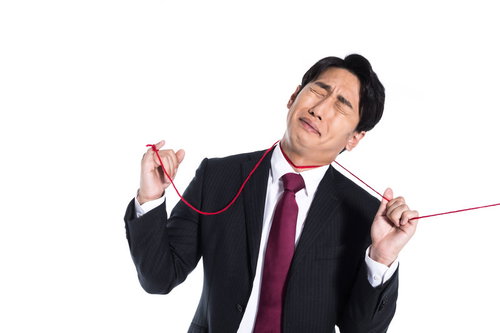 赤い糸に運命を握られ拘束される男性の困惑した表情