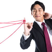 赤い糸を引く恋愛上手の若手社員スーツビジネスマンの写真