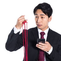 赤い糸が全部切れてしまう、スーツ姿の男性の写真
