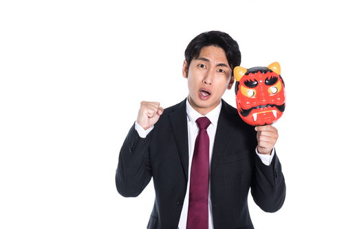赤い鬼の面を手に怒りをあらわにするスーツ男性