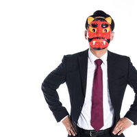 スーツ姿で鬼のお面をかぶり腰に手を当てた男性の写真