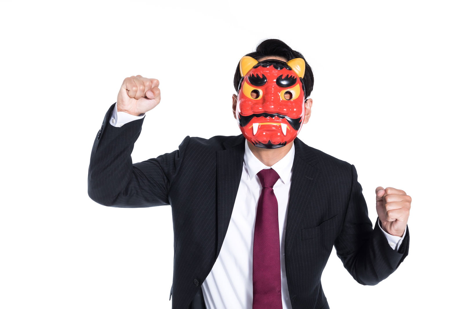 赤い鬼の面をかぶり両腕を握りこぶしに上げたスーツ姿の男性［モデル：大川竜弥］