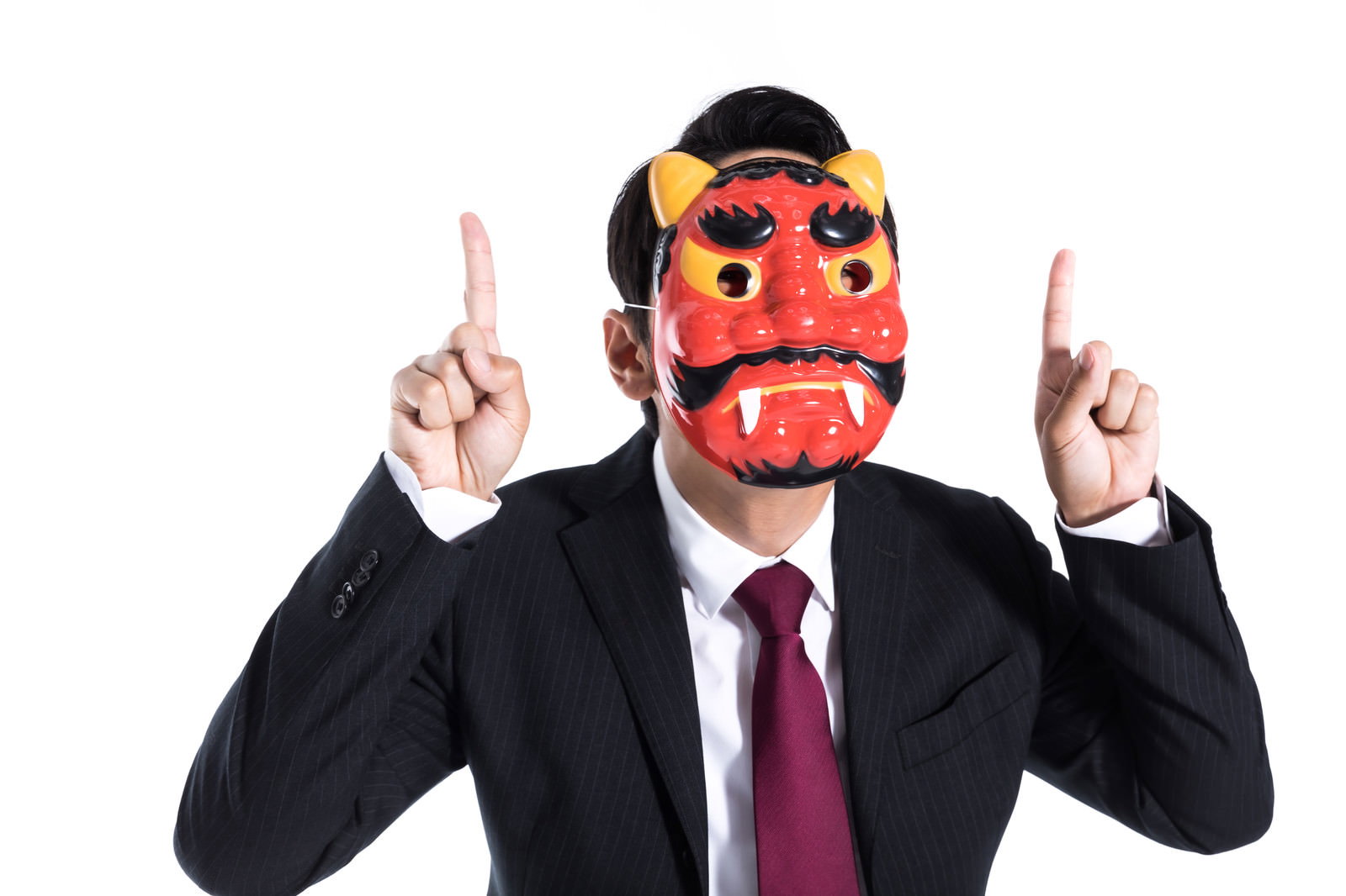 タオルを噛んで怒りを堪えるスーツ姿の男性［モデル：大川竜弥］