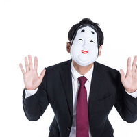 怪しい者ではありませんと両手を上げる詐欺師のお面姿の写真