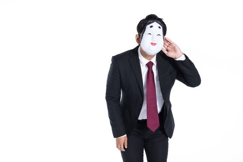 仮面を被ったスーツ姿の男性のお辞儀と挨拶