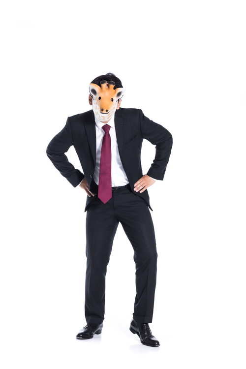威嚇的な態度を取る匿名社員・仮面をかぶったスーツ姿の男性