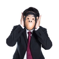 聞かざる～両手で耳をふさぐスーツ姿の男性の写真