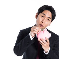 趣味は500円貯金です。ピンクの貯金箱を抱えるスーツ姿の男性の写真