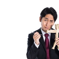 断ったら呪いますと脅迫する藁人形と五寸釘を持つ営業マンの写真