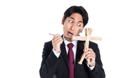 五寸釘と藁人形を持つスーツ姿の復讐代行人