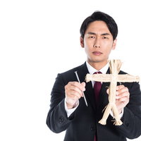 上司へ不満があるなら藁人形と五寸釘を持つ会社員の写真