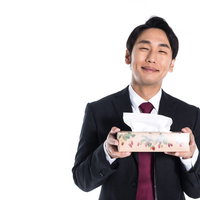 花粉の季節に箱ティッシュを持参する執事男性の写真