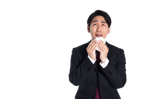 感動で涙ぐむサラリーマン、白いハンカチで目元を押さえる