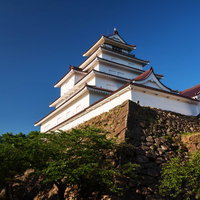 会津の鶴ケ城の天守閣と石垣の歴史的風景を記録した写真の写真