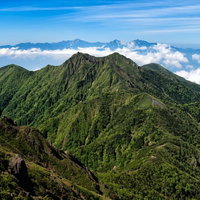 権現岳と南アルプスの山脈が連なる景観と登山道の眺望の写真