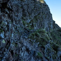 横岳の急峻な岩場にある登山用の鎖場と険しい登山道の写真