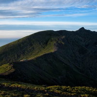 横岳へと果てしなく続く登山道と山脈の稜線の写真