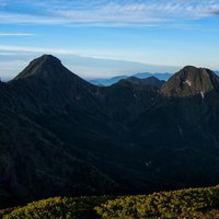 日に照らされた深い渓谷を有する山並みと連峰の写真
