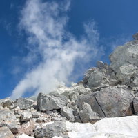盛んに噴気を出す焼岳の噴気孔と岩肌の写真
