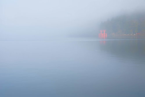 朝靄に包まれた芦ノ湖に浮かび上がる箱根神社の赤い鳥居